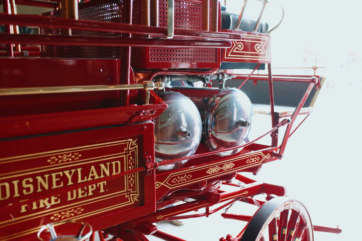 Seitenansicht eines roten Oldtimer-Feuerwehrautos mit goldenen Verzierungen.